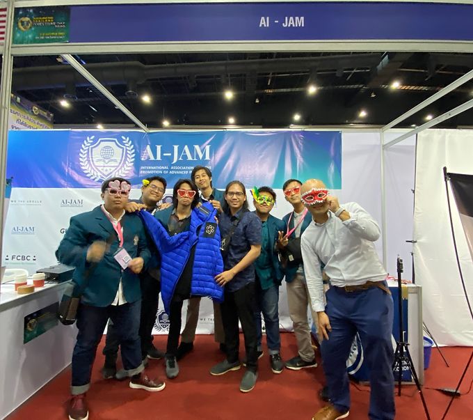A team of students in blazers posing with masks at an exhibition booth