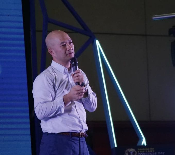 Speaker with a microphone on a stage lit in blue