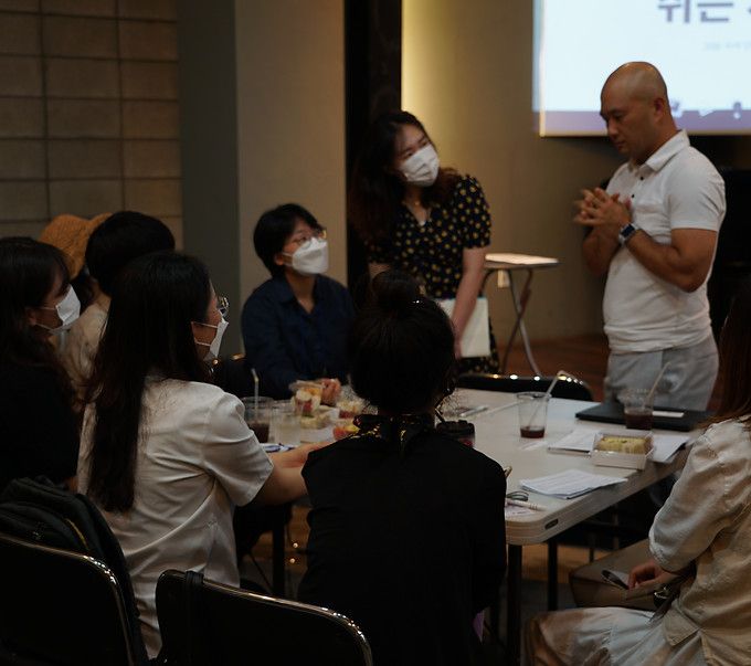 Mentor speaking with students seated around a table
