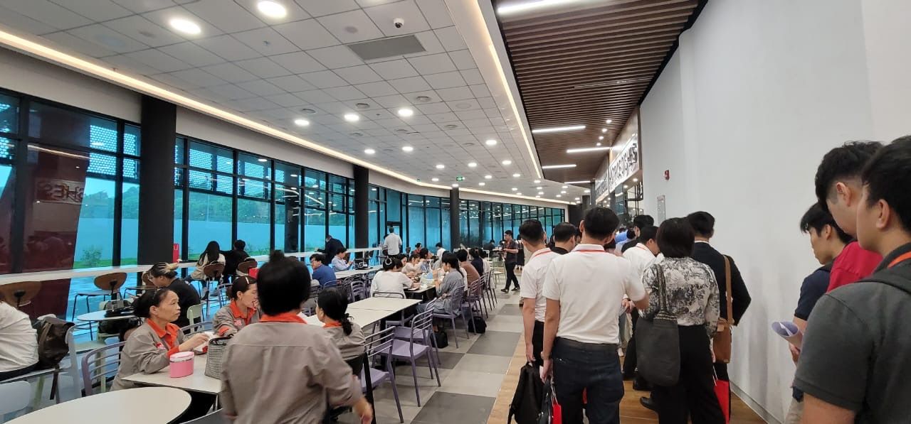 Participants standing and talking in a bright venue hallway