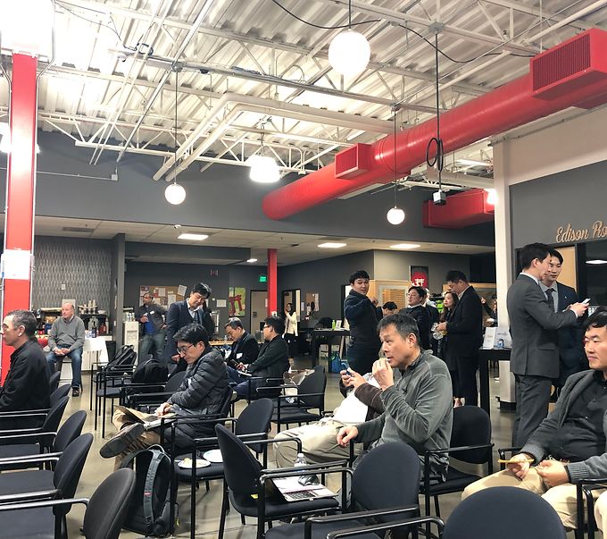 Audience seated in an industrial-style venue listening to a talk